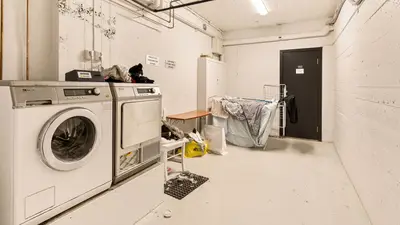 Spacious laundry room featuring washing machine and dryer with visible piping.