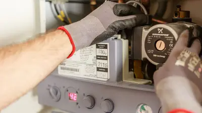 Close-up of hands adjusting a boiler system with precise instrumentation, showing maintenance work.