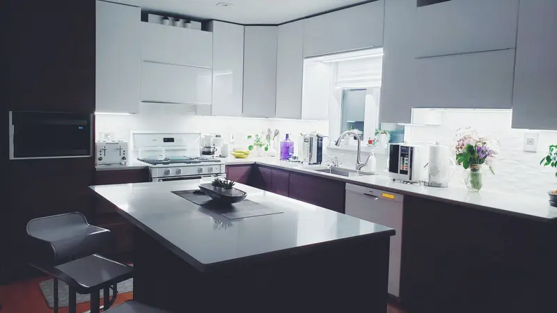 Contemporary kitchen interior with sleek white cabinets and island, perfect for a minimalist aesthetic.