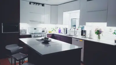 Contemporary kitchen interior with sleek white cabinets and island, perfect for a minimalist aesthetic.