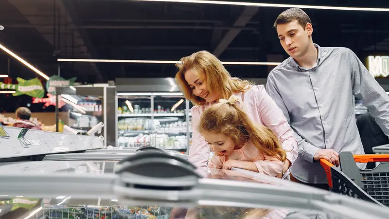 A family enjoying time together while shopping in a supermarket aisle.