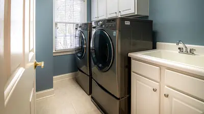 A clean, organized laundry room featuring modern appliances and ample storage.