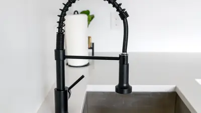 Sleek black faucet on white countertop in modern kitchen. Ideal for minimalist and contemporary designs.