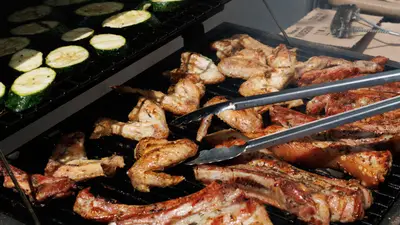Delicious barbecue chicken and zucchini grilling outdoors on a sunny day.