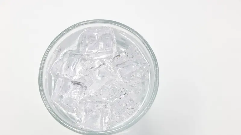 Refreshing ice cubes in a glass on a white background, perfect for drink and lifestyle themes.