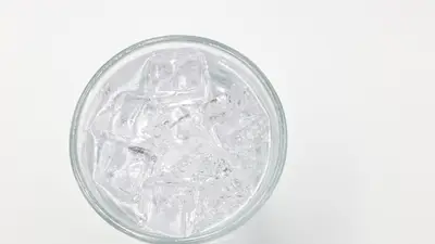 Refreshing ice cubes in a glass on a white background, perfect for drink and lifestyle themes.