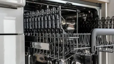 A detailed view of an empty modern dishwasher rack showcasing its stainless steel construction.