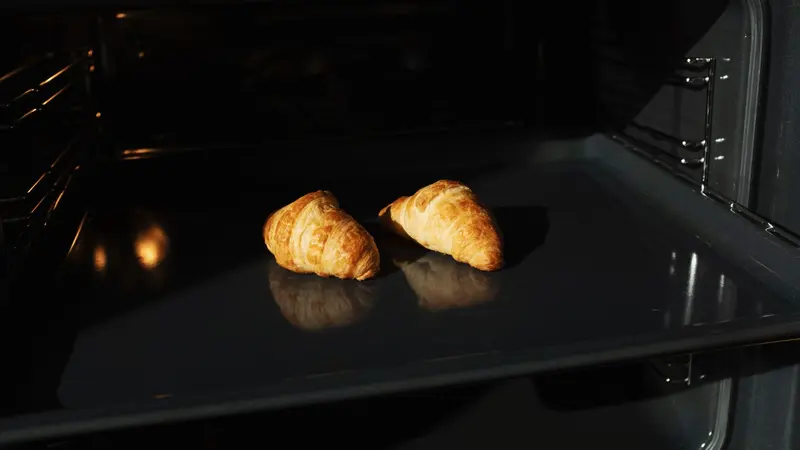 Golden croissants baking in an oven, capturing the perfect homemade pastry moment.