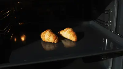 Golden croissants baking in an oven, capturing the perfect homemade pastry moment.