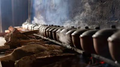 Rows of steaming clay pots in a traditional Vietnamese kitchen in Nam Định, Vietnam, create an authentic culinary atmosphere.
